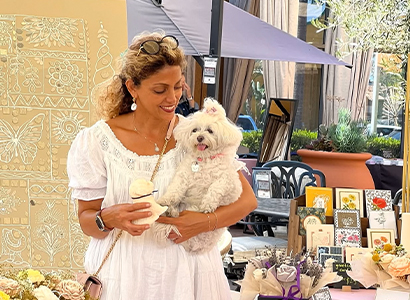 Woman at market holding small white dog