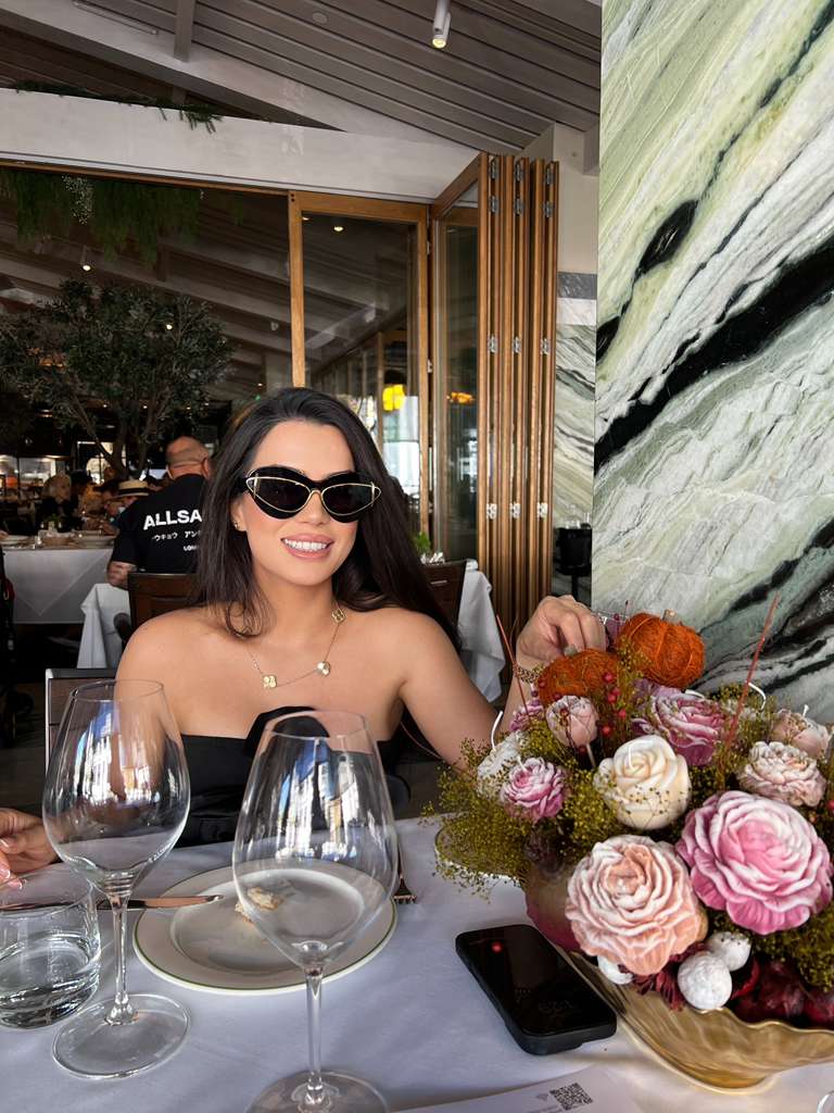 Smiling woman in sunglasses at restaurant table